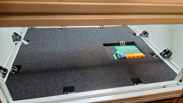 Близък план на установка за визуална инспекция на печатна платка с монтирани компоненти.